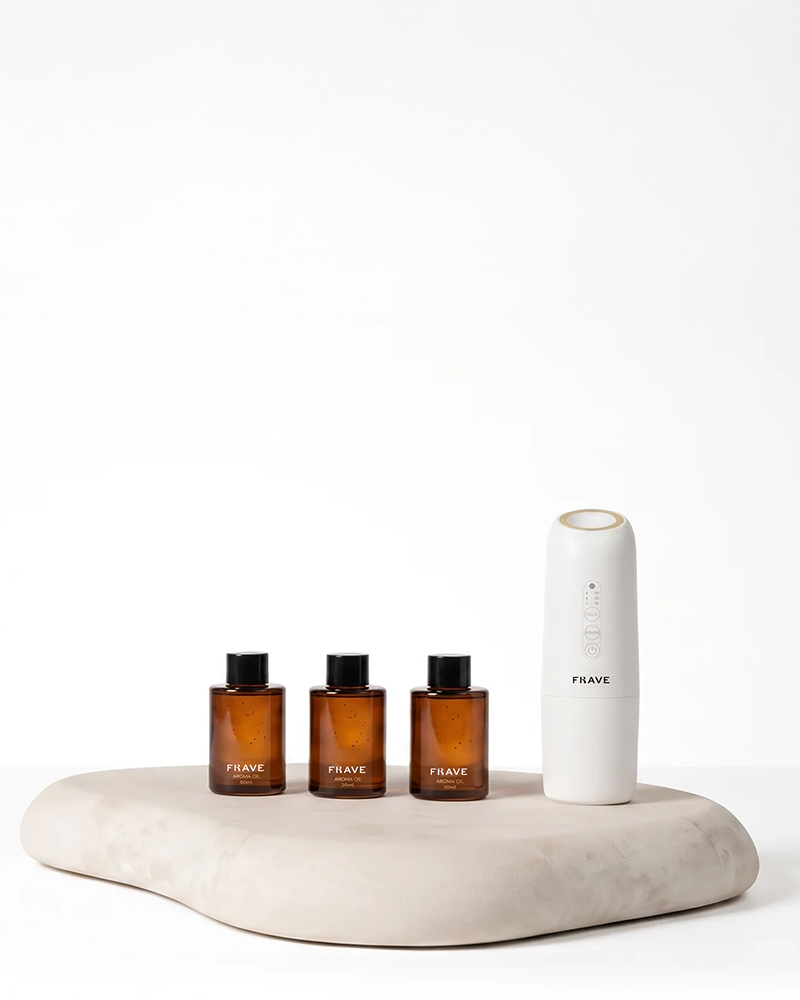 FRAVE Lumix diffuser and three aroma oils on a stone display